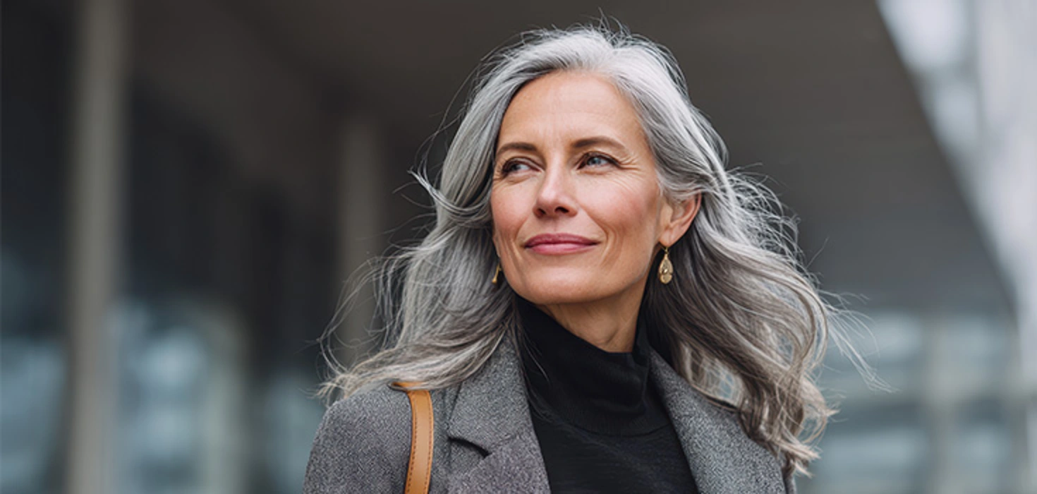 Ältere Dame mit grauen Haaren und schicker Kleidung