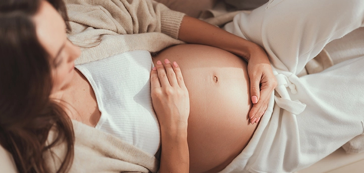 Ausschnitt einer schwangeren Frau, die sich den Bauch hält