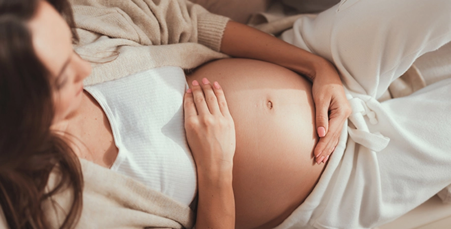 Ausschnitt einer schwangeren Frau, die sich den Bauch hält