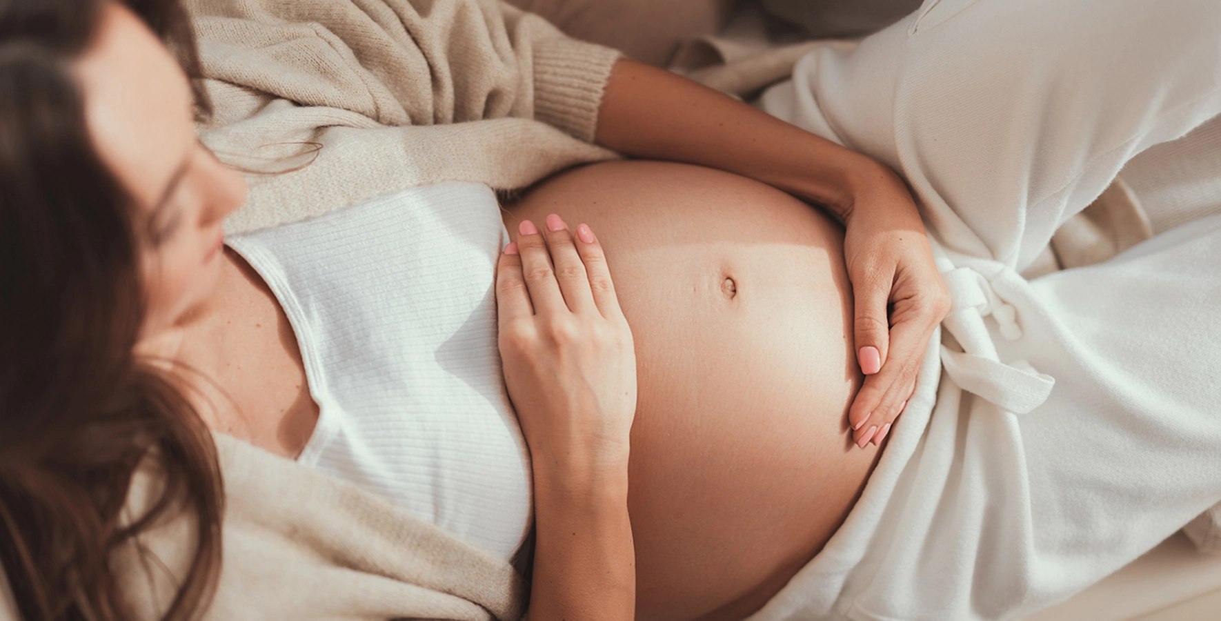 Ausschnitt einer schwangeren Frau, die sich den Bauch hält
