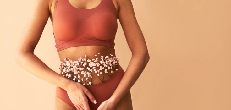 Frau in Unterwäsche, der Blumen aus der Hose wachsen